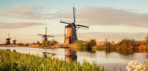 A photo of a landscape in Holland, featuring a windmill