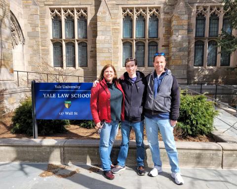 Jeremy Rodrigues stands between his parents on a sunny day in front of Yale Law School.