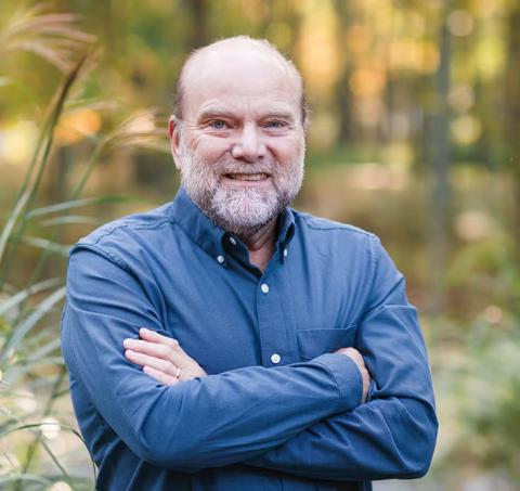 Joseph Helpern smiles at camera in an outdoor setting while wearing a collared shirt