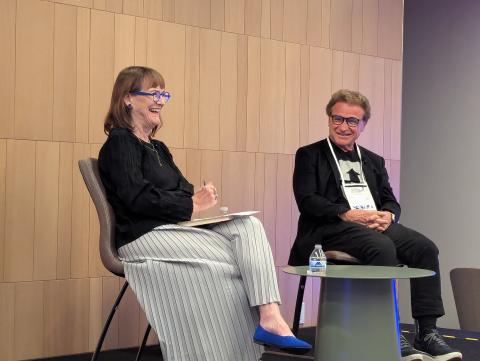 Norman Aladjem (WRC) and Karen Kaler speak on stage while wearing formal attire