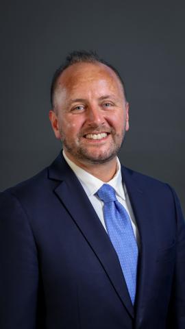 photo of Jeffrey Verespej wearing a blue jacket and royal blue tie