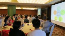 Photo of students at the Shanghai Summer Send-Off, gathered around tables looking at a presentation