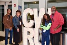 Four people pose by CWRU sign