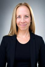 Rebecca Weisberg smiles at camera while wearing formal attire