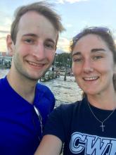 Couple smiles at camera in outdoor setting