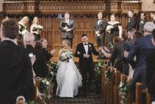 Couple walks down the aisle at their wedding in a celebratory scene