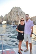 Couple smiles at camera in outdoor setting, on the water