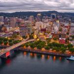 Portland, Oregon, skyline against cloudy sky, behind water