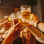 Friends raise glasses of beer in a toast