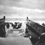 Soldiers in black and white uniforms stand on the beach, ready for duty.