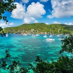 A Caribbean port shown in the daytime, with a sunny sky with some clouds