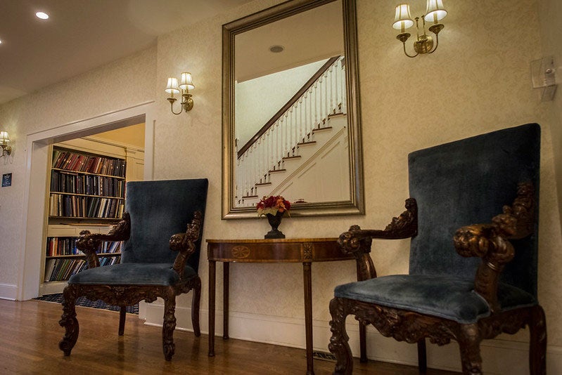 Blue chairs seated next to an end table on the first floor of the Linsalata Alumni Center of Case Western Reserve University