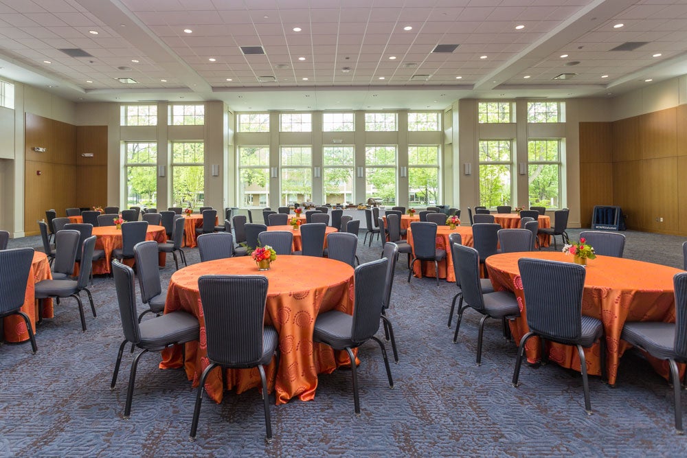The Great Hall at the The Linsalata Alumni Center with tables set up in front of the large floor to ceiling windows 