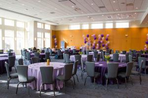 The Great Hall at the The Linsalata Alumni Center decorated for an event with purple tables and balloons