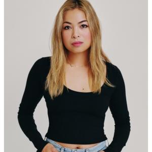 Image of woman with long blond hair wearing a long sleeve black top and jeans