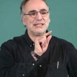 Man in front of green board