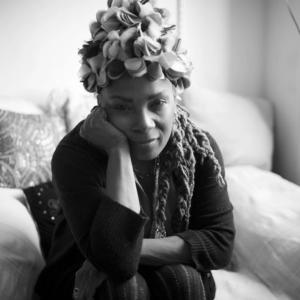 Black and white image of African American women sitting on a bed with her hand on her shoulder