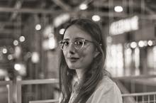 Black and white image of woman with long dark hair and glasses