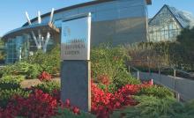 Color image of Cleveland Botanical Garden building and sign with red flowers and lots of greenery in front