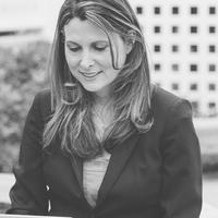 Black and white image of white woman with long brown hair looking down outside of a building