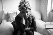 Black and white image of African American women sitting on a bed with her hand on her shoulder