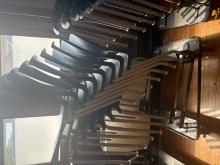 Image of 8 blue plastic chairs stacked on a rack