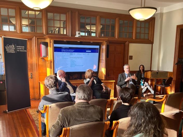 A group of faculty members talk together in a seminar.