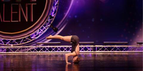 Megan performing a headstand at a dance competition 