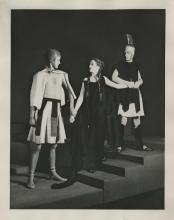 Vintage black and white image of two men and a woman in greek clothing on a stage