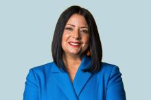 Image of woman with shoulder length dark hair wearing a bright blue suit jacket