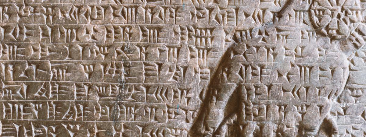 ancient Assyrian cuneiform carved on stone wall