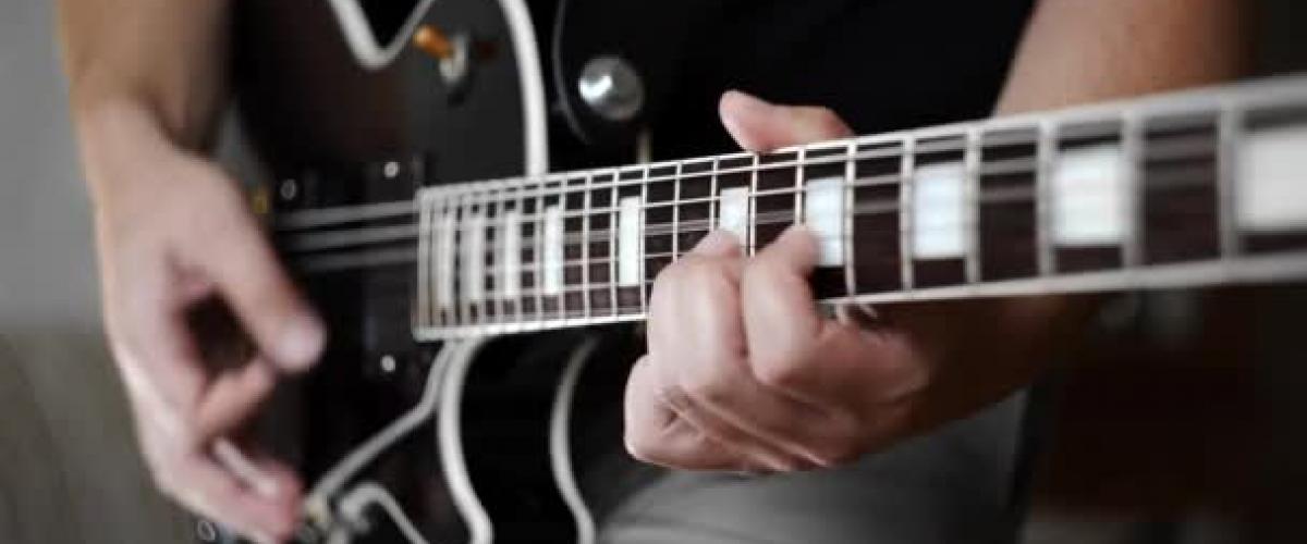 Photo of a person playing the guitar