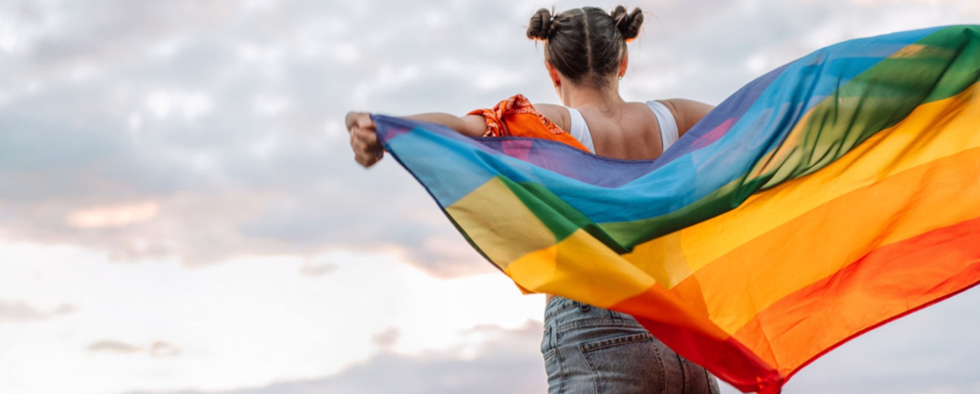 Woman facing away waving pride flag 