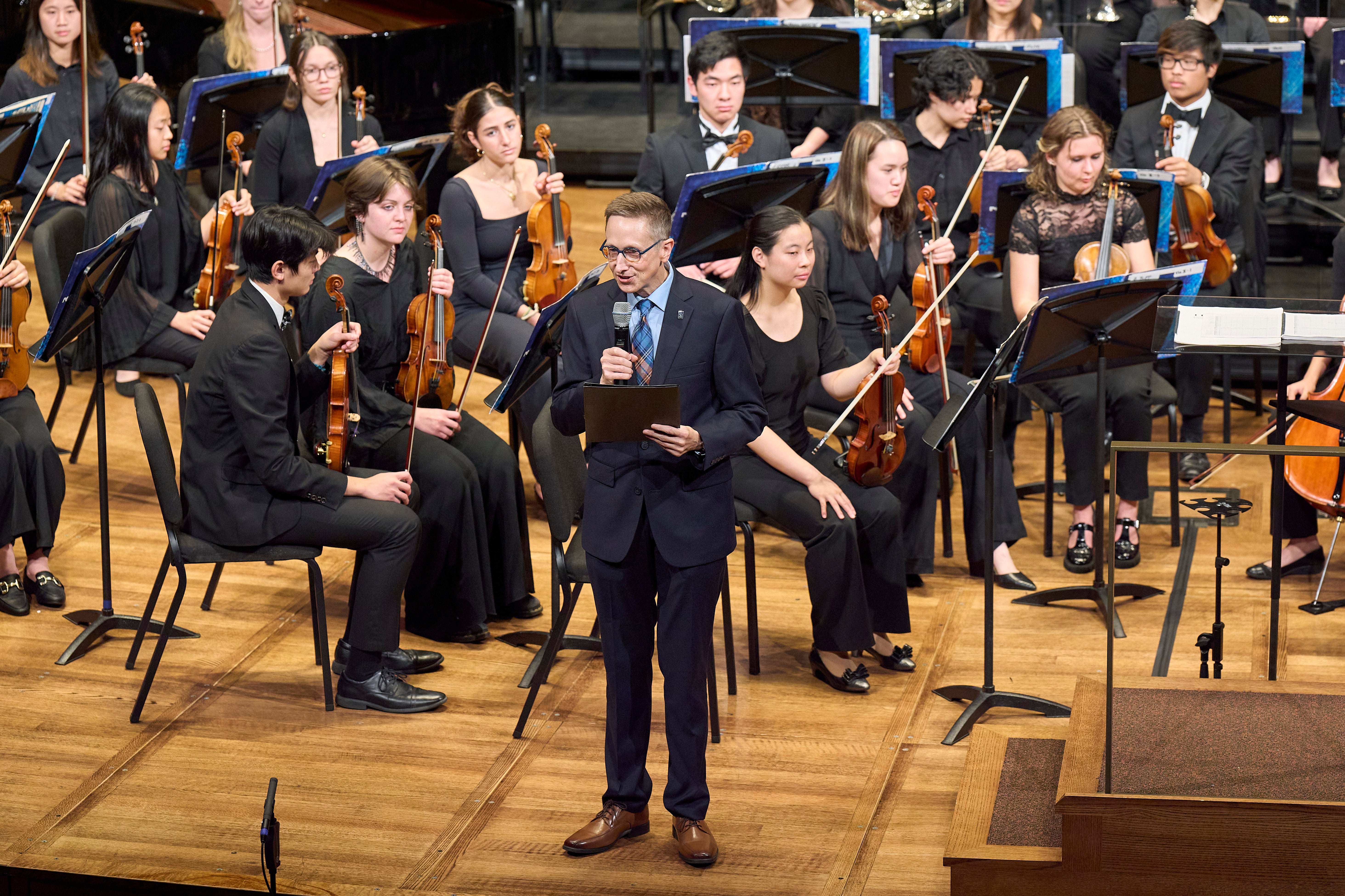 Nate Kruse speaking at MPAC concert in front of orchestra