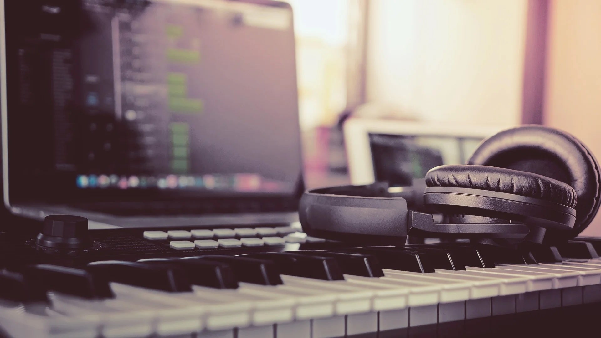 Stock photo of music technology computer, keyboard, and headsphones.