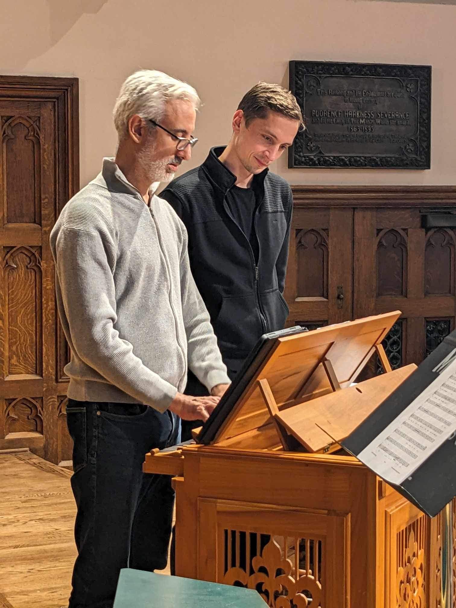 Mikhail Grazhdanov standing with instructor next to organ