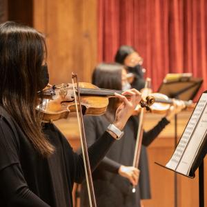 Orchestra students perform masked at the Maltz Performing Arts Center