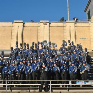 Spartan Marching Band in uniform in the stands at the football stadium.