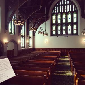 Harkness Chapel looking off stage into hall with Tiffany glass window