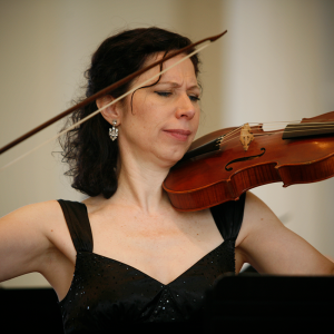 Julie Andrijeski playing baroque violin in black sparkling dress.