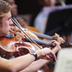 Photo of a student playing a string instrument