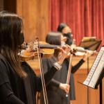 Orchestra students perform masked at the Maltz Performing Arts Center