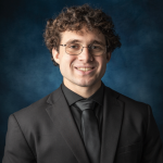 Andrew Director, Tuba, Headshot, wearing black suit and tie