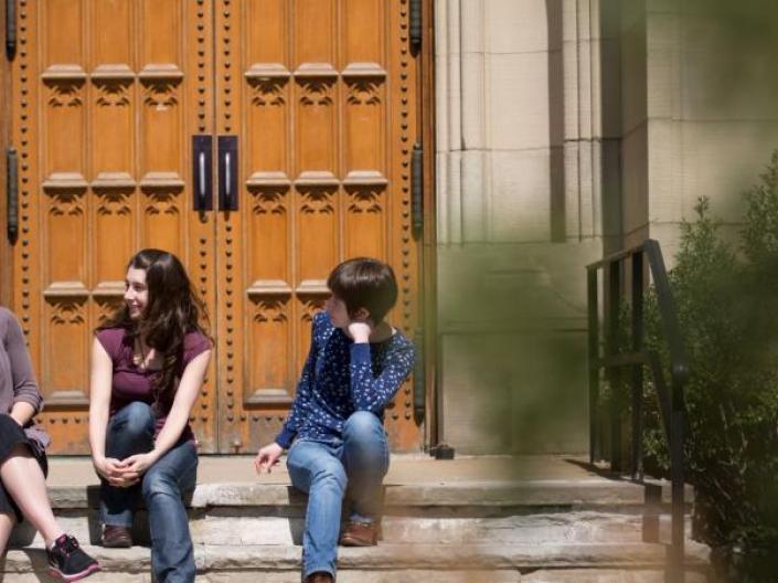 Student sitting in front of Harkness Chapel