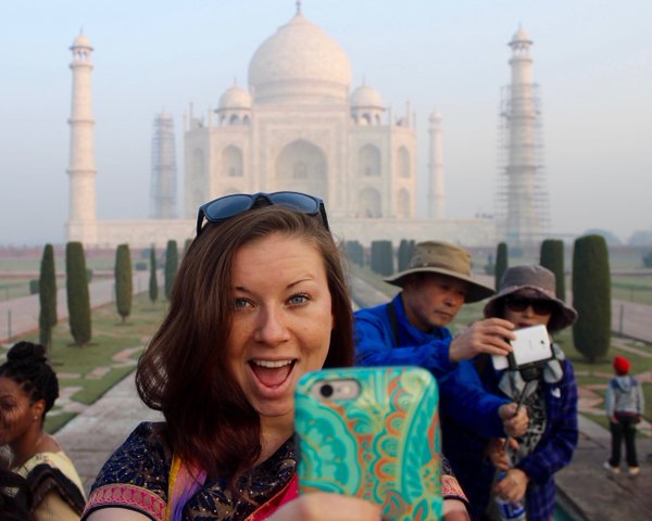 student taking a selfie in front of the taj mahal