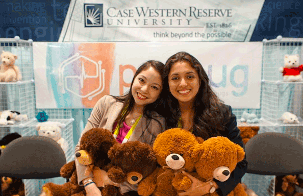 two students holding teddy bears