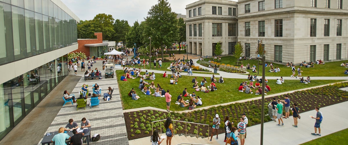 The image features CWRU's campus community scatter on the Thwing center lawn enjoy a sunny day