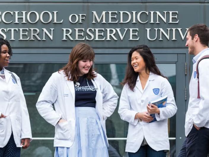 Four medical students standing in front of Case Western Reserve University sign