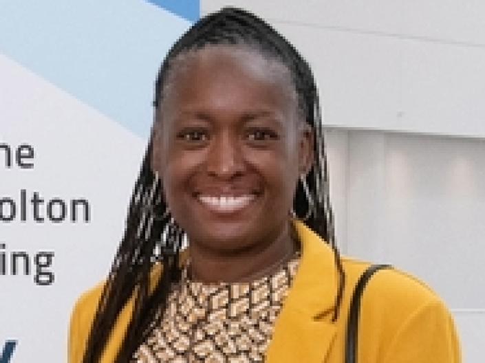 Aisha K. Mix smiles at camera while wearing formal attire