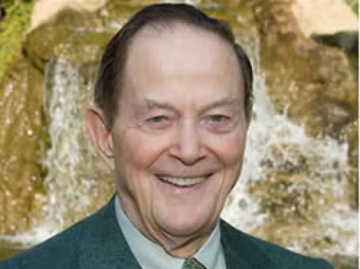 Albert J. Weatherhead III smiles at the camera in an outdoor setting while wearing formal attire
